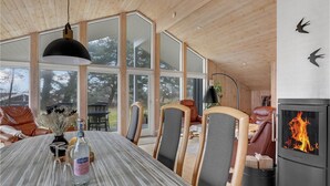 A modern interior with a large dining table, chairs, a fireplace, and large windows. - Stunning home in Aakirkeby with WiFi (Aakirkeby)
