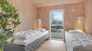 A room with two beds, wooden walls, a large window, and a view of the outdoors. - Stunning home in Aakirkeby with WiFi (Aakirkeby)
