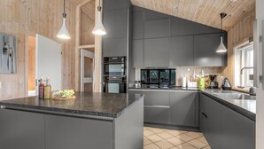 A modern kitchen with grey cabinets, a granite countertop, and pendant lighting. - Stunning home in Aakirkeby with WiFi (Aakirkeby)