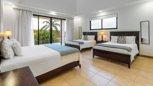 A hotel room with two beds, a ceiling fan, and large windows with curtains.
