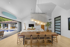 Um interior moderno com área de jantar, uma janela grande e vista para uma piscina.