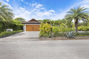 Uma casa moderna com porta de madeira e o número 84 na parede.