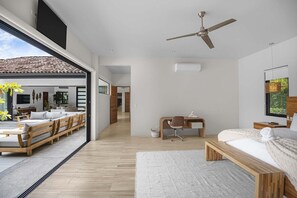 A modern bedroom with a bed, desk, and seating area.