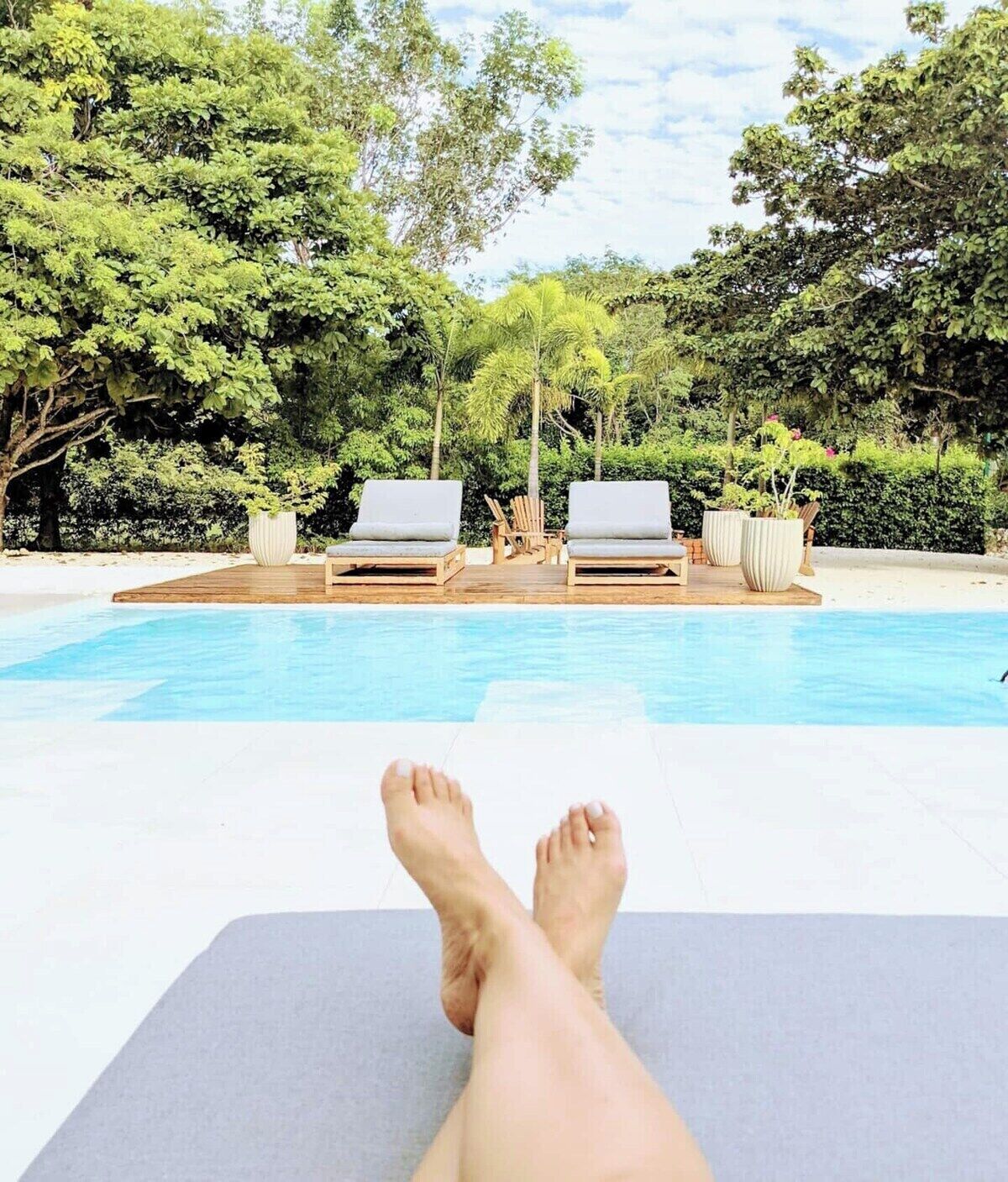 A poolside area with lounge chairs and a wooden deck.
