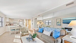 Una sala de estar moderna con un sofá, una mesa de centro y una zona de comedor con sillas y una mesa.