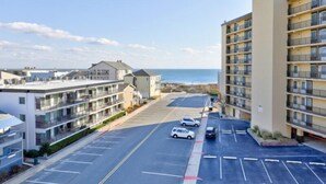 Un hotel de varios pisos con estacionamiento y vista al mar.