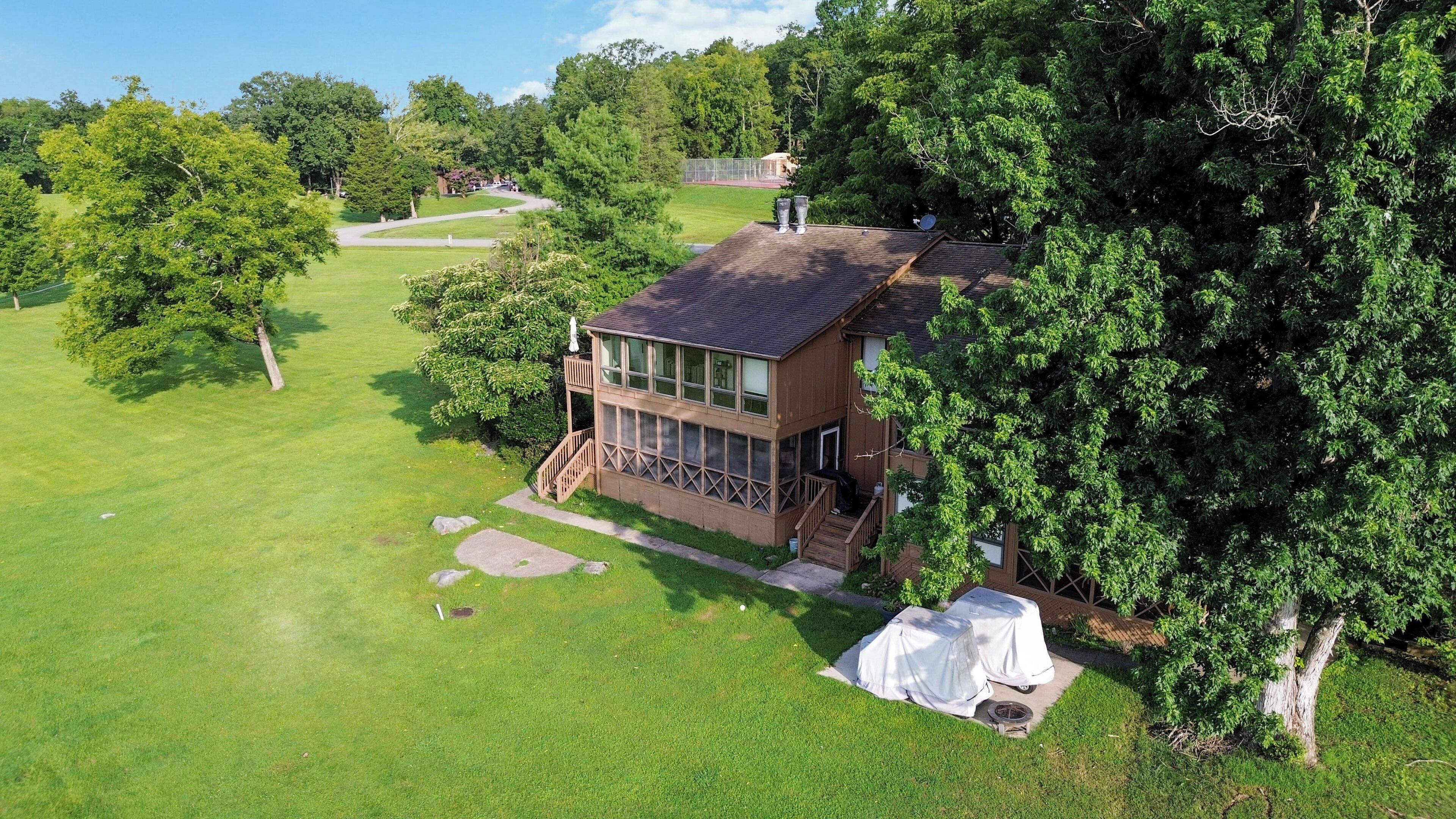 A two-story house with a large deck and a covered outdoor seating area.