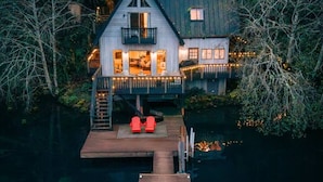 Una casa con balcón, muelle y chimenea.