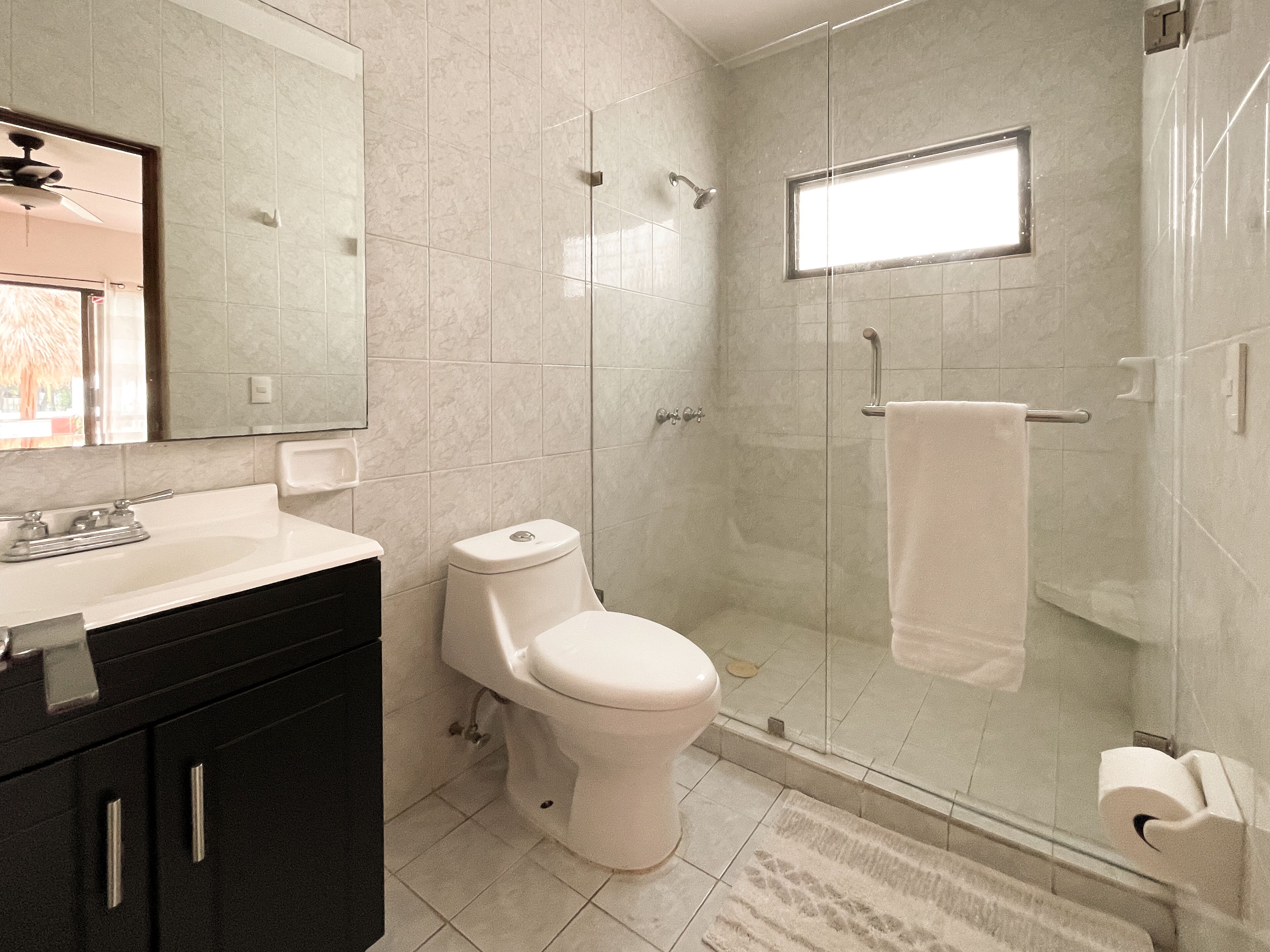 Une salle de bain moderne équipée de toilettes, d’un lavabo et d’une douche.