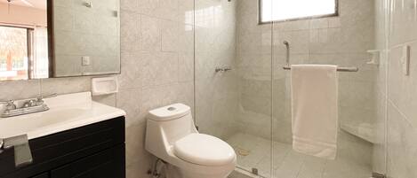 Une salle de bain moderne équipée de toilettes, d’un lavabo et d’une douche.
