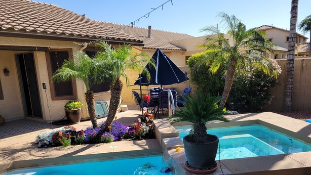 A swimming pool with a tiled deck, surrounded by potted plants and a patio area with outdoor furniture. - "Cactus Cooler Casita" Private Pool and Heated Spa Included Large walk-in Shower (Queen Creek)