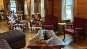 A cozy room with wooden beams, a wooden table with a tray, and two patterned armchairs.
