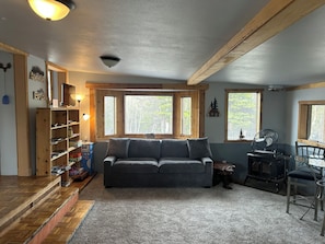 Ein gemütliches Wohnzimmer mit einer Couch, einem Holzregal, einem Kamin und einem Essbereich.