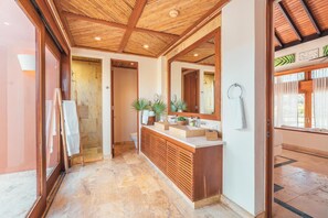 A modern bathroom with a wooden ceiling, a large mirror, and a marble floor.