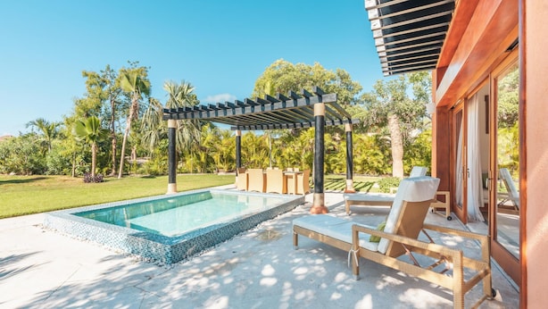 A swimming pool with a pergola, lounge chairs, and a garden with palm trees. - Bungallow 2 People Private Pool and Garden (Punta Cana)