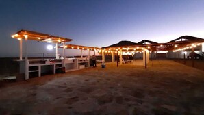 Un espace extérieur aménagé en terrasse, avec plusieurs coins salon et un bar.