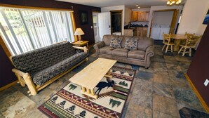 A living room with a sofa, a coffee table, and a patterned rug. - Rocky Mountain Retreat 1A- 4 bedroom/3 bath with personal hot tub offers Panoramic Mountain Views 4 Cabin (Estes Park)