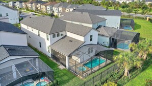 Een woonwijk met moderne huizen, een zwembad en een overdekt terras.
