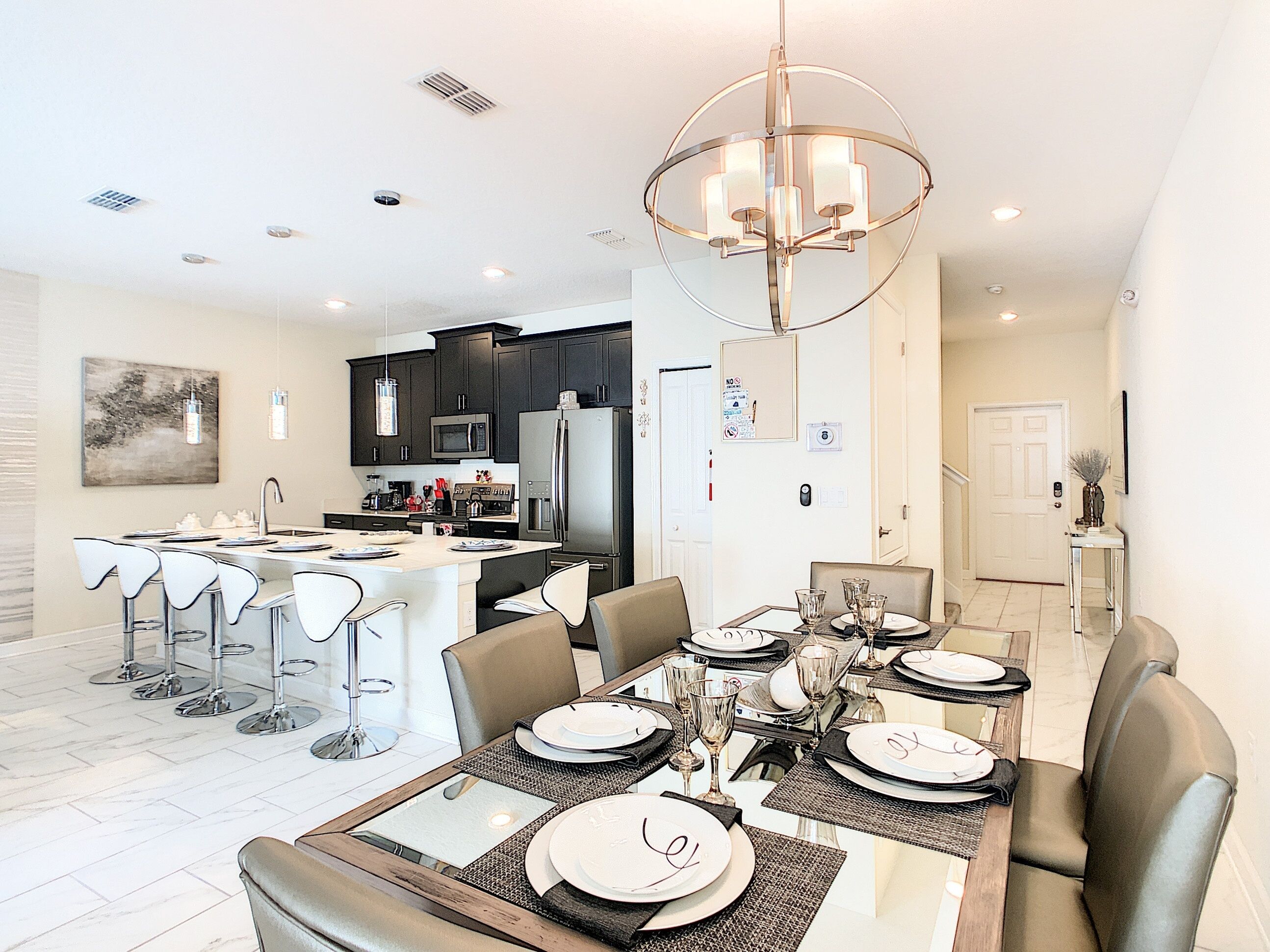 A modern kitchen with dark cabinets, a stainless steel refrigerator, and a microwave.