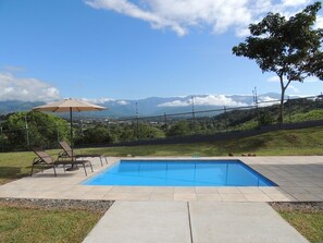A rectangular swimming pool with a clear blue water surface, surrounded by a paved deck. - Spacious 2-Bedroom Casita with Pool, and Modern Amenities in Perez Zeledon (San Isidro de El General)