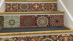 A staircase with ornate, colorful tiles and wooden handrails.
