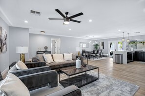 A modern living room with a sofa, coffee table, and a ceiling fan. - Minutes from Shopping, Dining & Golf (Scottsdale)