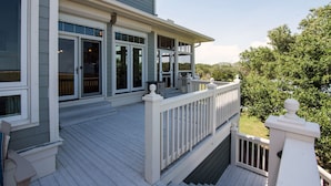 A two-story house with a covered porch and a deck.