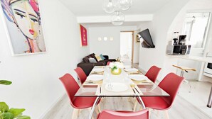 Un comedor moderno con una mesa de vidrio, sillas rojas y una decoración minimalista.