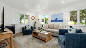 Ein Wohnzimmer mit einer Couch, Sesseln, einem Couchtisch und einem Kamin.