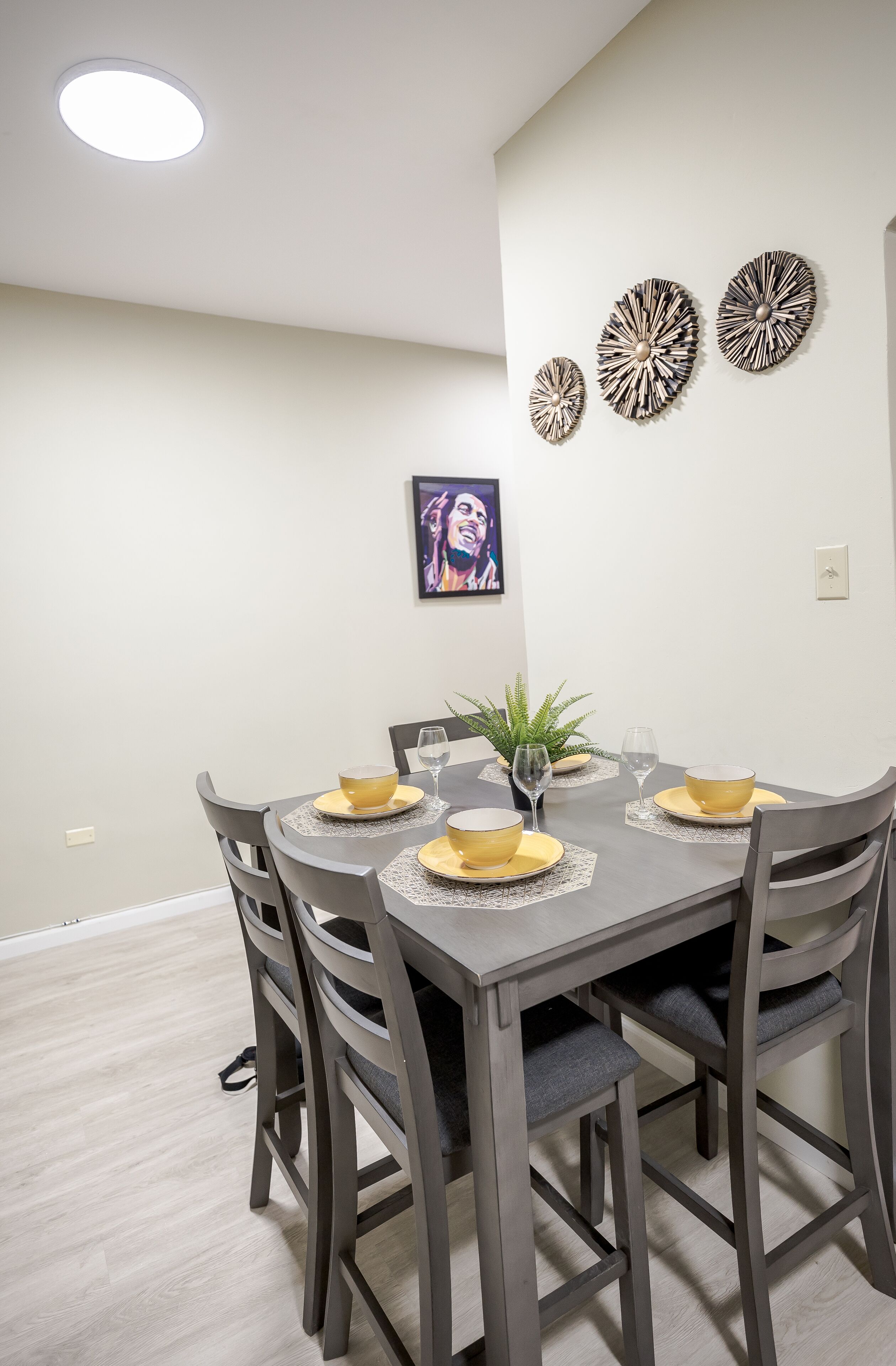 A dining area with a gray table set for four, surrounded by matching chairs.