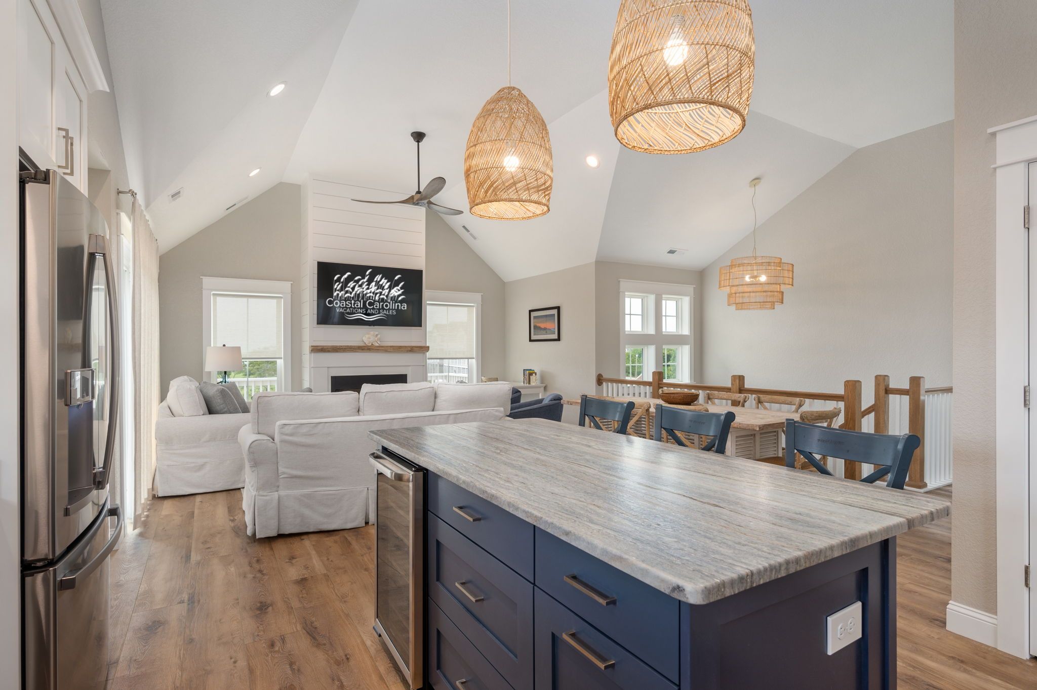 A spacious kitchen with a large island, modern appliances, and a dining area with wooden chairs.