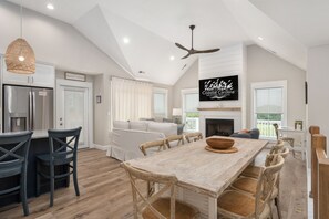 A spacious kitchen with a dining area, a fireplace, and a television mounted above it.