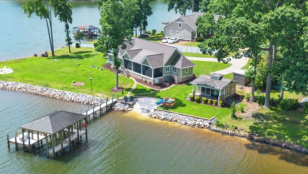 A lakeside property with a dock, a house, and a boat.
