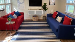 A living room with two sofas, a TV, and a large window. - Bright & Cozy, Yarmouth Cape Top Beaches! (Yarmouth)