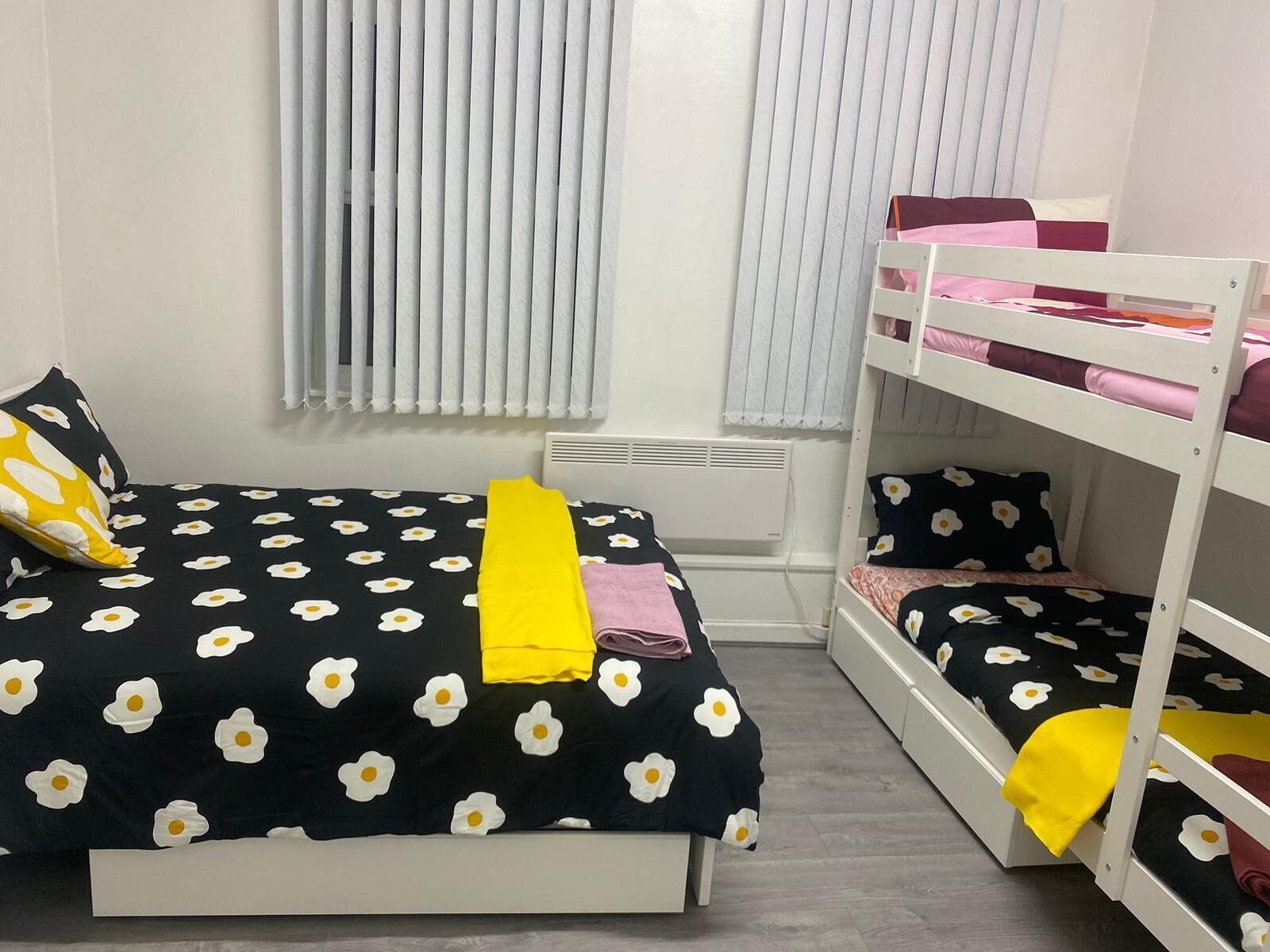 A bedroom with a single bed, a bunk bed, and a radiator.