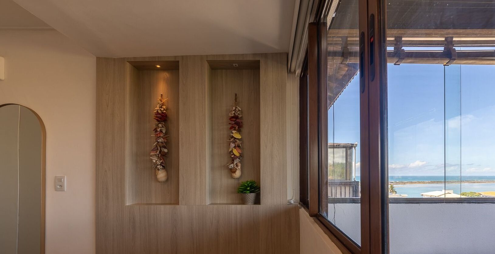 Un pasillo con paneles de madera y vista al océano a través de un ventanal grande.