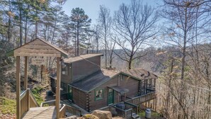 A rustic cabin with a wooden deck, a green door, and a 'Logged Out' sign. - Cozy Tucked Away Log Cabin- Lake/Mountain views! (Lake Lure)