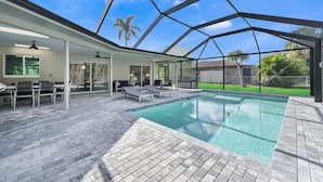 A covered outdoor swimming pool with lounge chairs and a patio area. - PROMO 5% WEEKLY AND 10% MONTHLY DISCOUNT
Tropical Dream House with Pool (Naples)