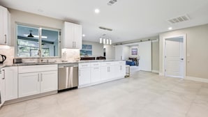 A spacious kitchen with white cabinetry, a built-in dishwasher, and a large island. - PROMO 5% WEEKLY AND 10% MONTHLY DISCOUNT
Tropical Dream House with Pool (Naples)
