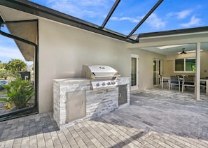 An outdoor patio with a built-in grill and seating area.