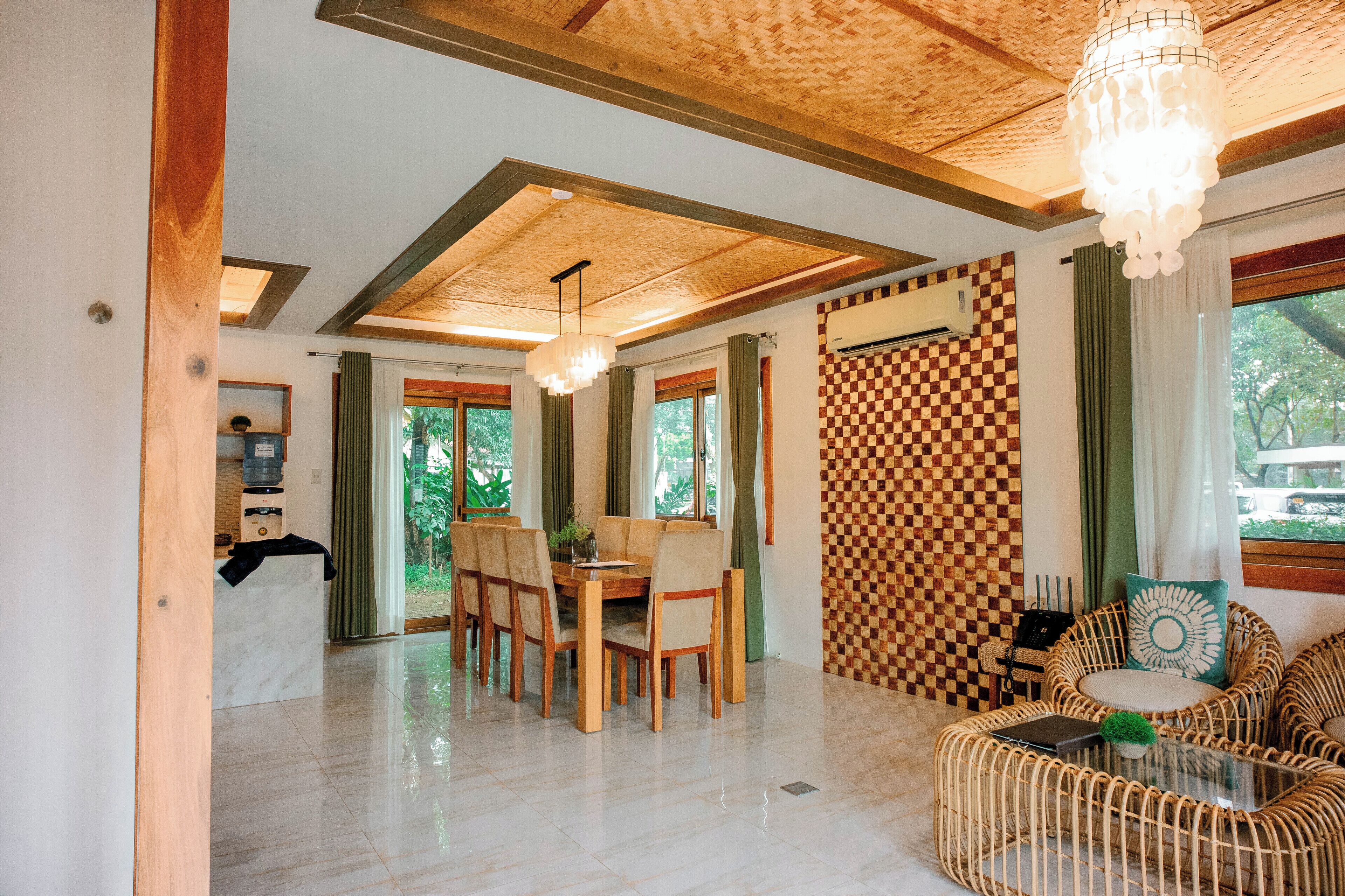 A dining area with a wooden table and chairs, a chandelier, and a checkered wall.