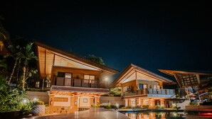 A modern hotel with a pool, large windows, and outdoor seating areas. - Estancia De Lorenzo (San Mateo)