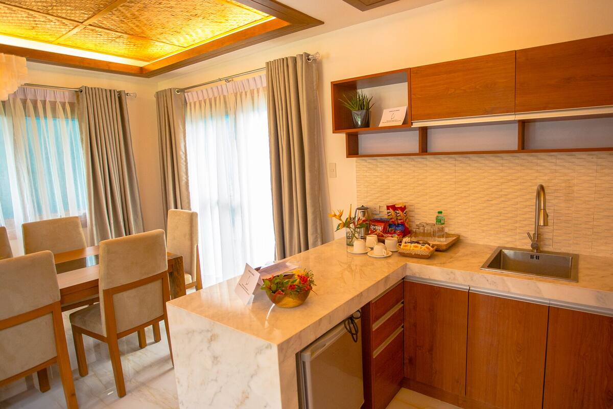 A modern kitchen with a marble countertop, wooden cabinets, and a built-in dishwasher.
