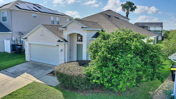 A residential area with houses, a garage, and a well-maintained lawn.