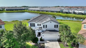 A residential area with houses, a pond, and a clear sky.