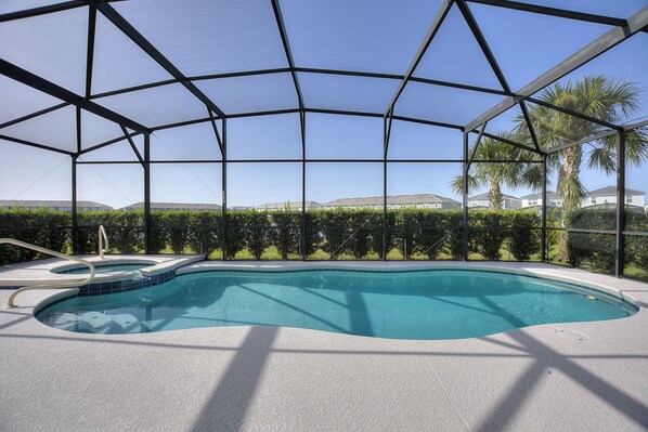 A swimming pool with a clear view of the surrounding landscape, including palm trees and distant buildings.