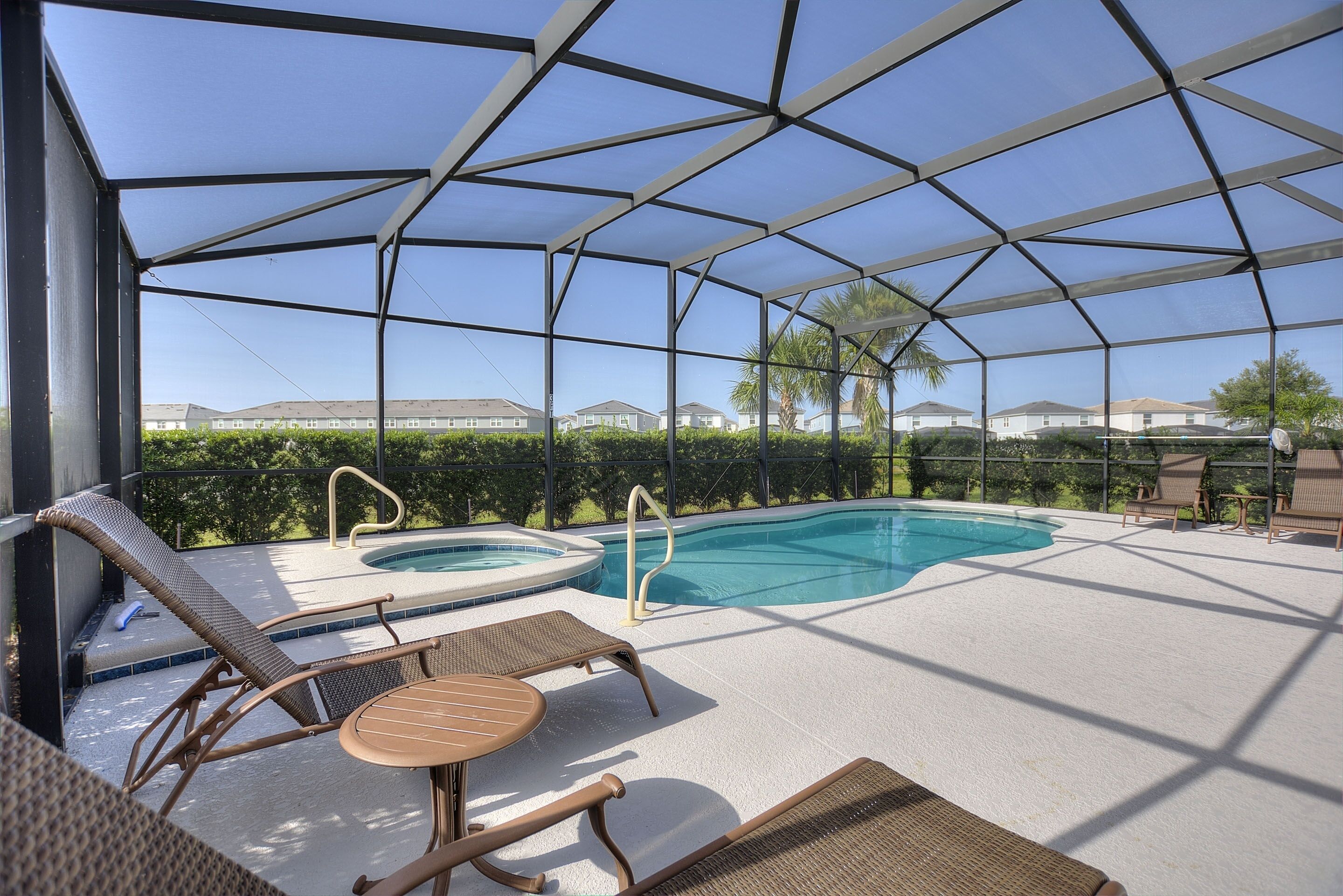 Un espace extérieur abrité avec une piscine, des chaises longues et un jacuzzi.