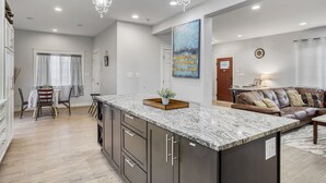 A modern kitchen with granite countertops, dark cabinetry, and pendant lighting. - Newly Built 5bed home 5 min from DT Portland in Laurelhurst Neighborhood (Portland)