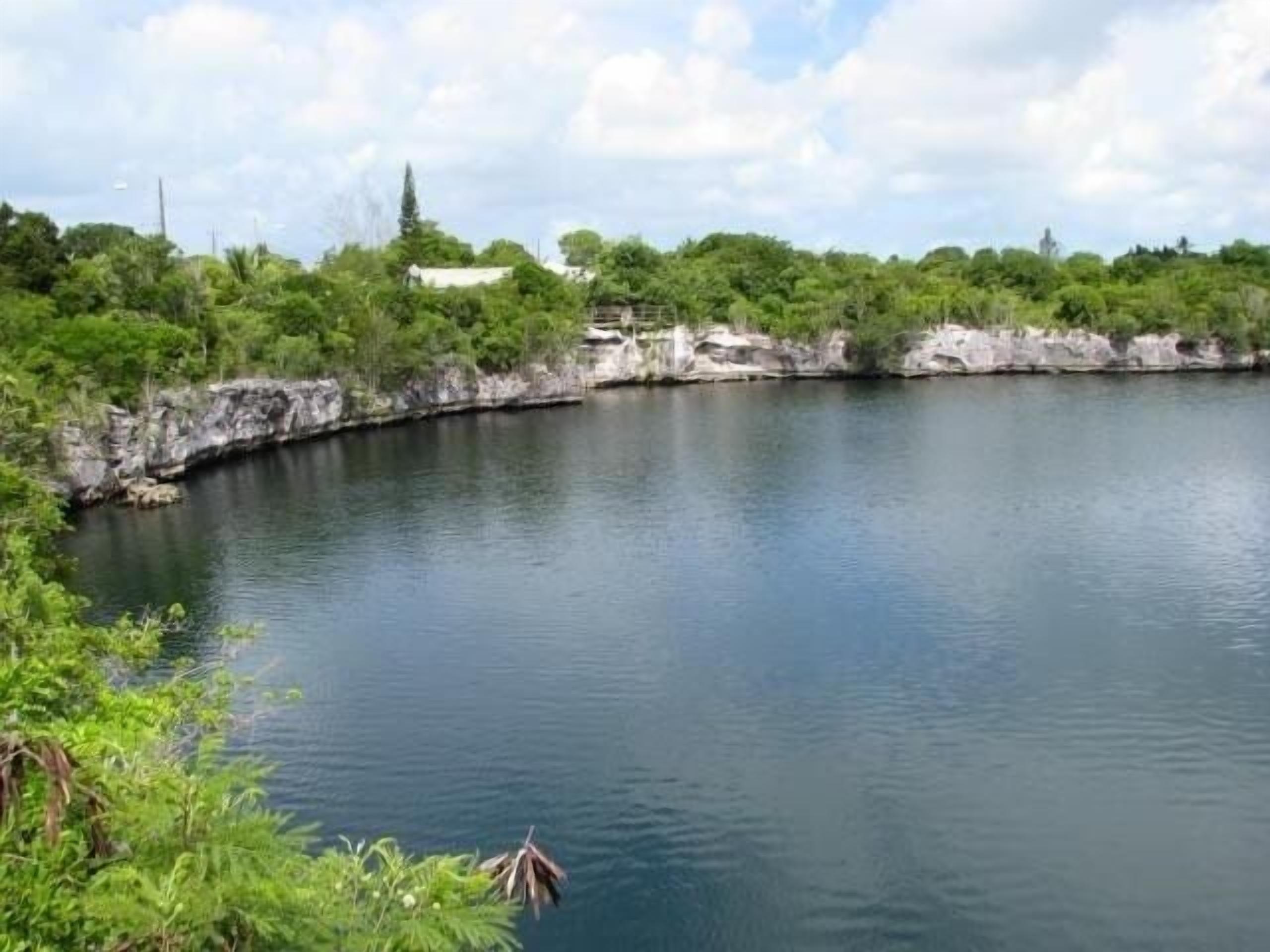Un lac paisible, bordé d’une végétation luxuriante et de falaises rocheuses.