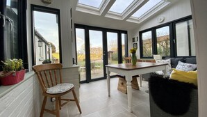 A bright room with skylights, a dining table, and a sofa.